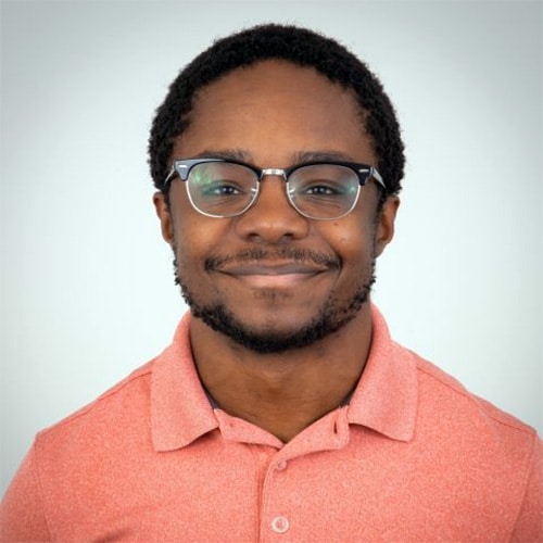 A headshot of Jabari Myles standing in front of a light gray wall.