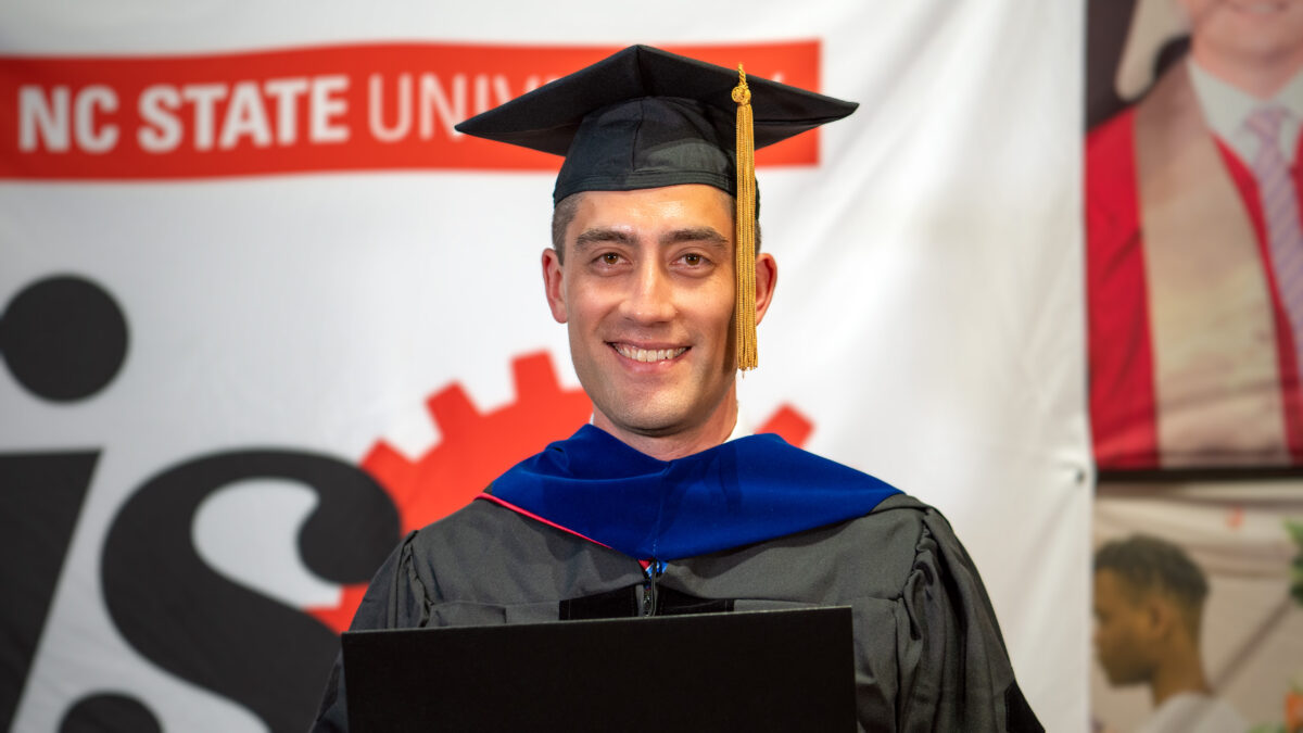 Ph.D. student Mathew Fukuzawa poses with his new degree.