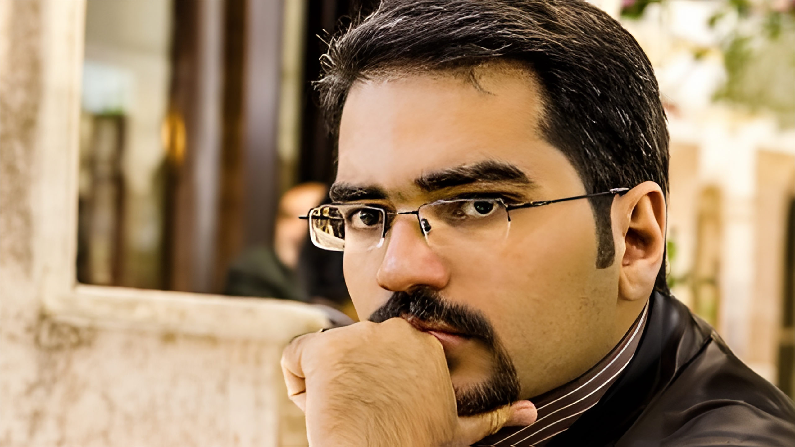 A headshot of Hossein Tohidi standing in front of a building.