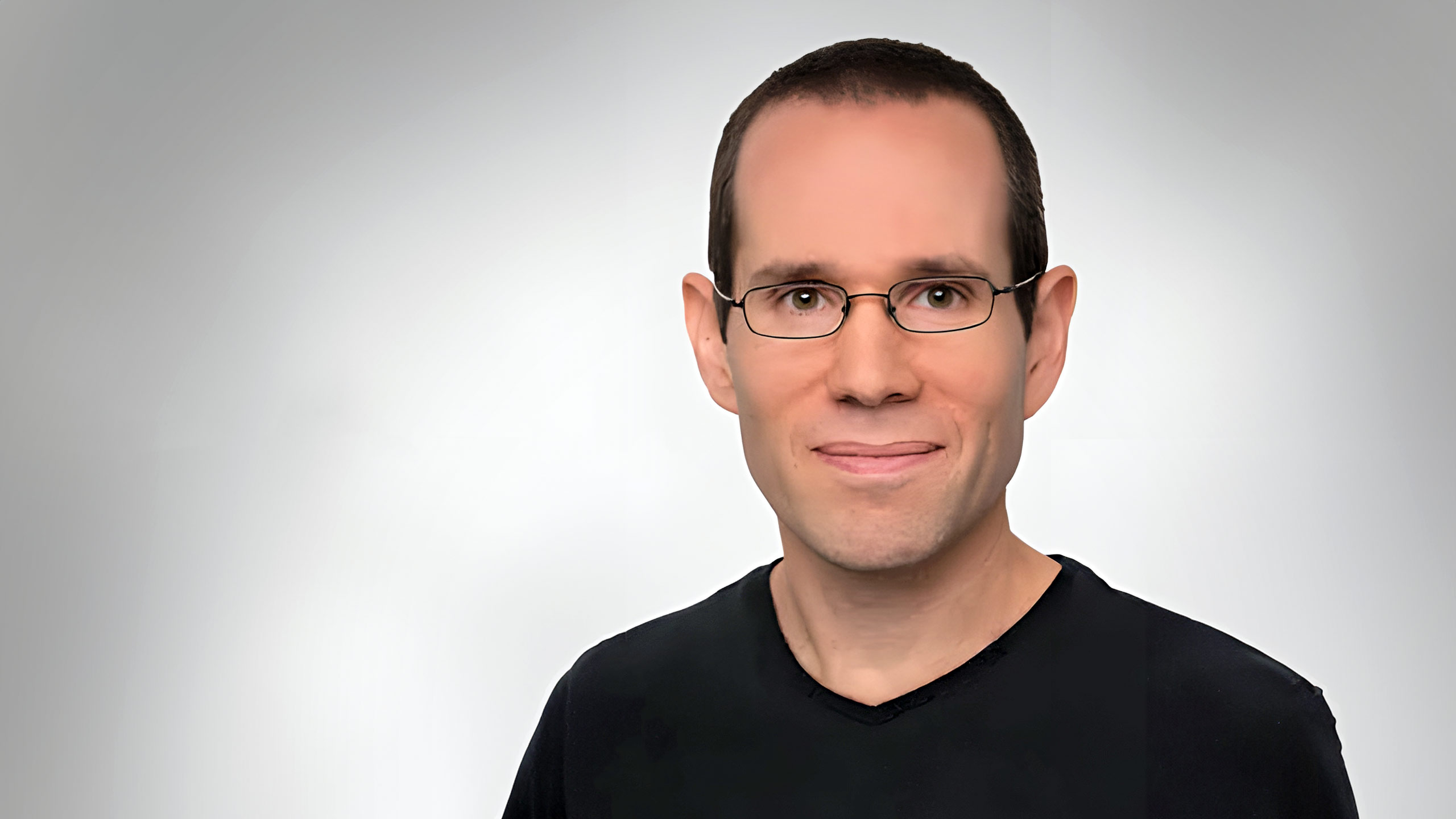 A headshot of Itai Gurvich standing in front of a white background.