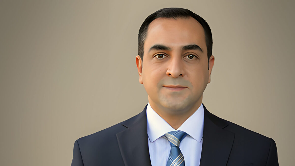 A headshot of Mohammad Hosseinian standing in front of a light brown background.