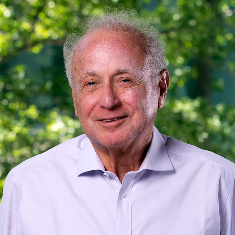 A headshot of Andres Weintraub standing in front of some trees.