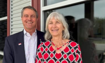 George and Grace Auten standing together outside of their company's building.