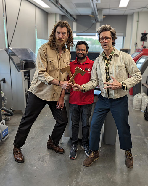 Rhett and Link wielding their peanut butter axes in front of Satya Konala in the CAMAL 3d-Printing Lab.