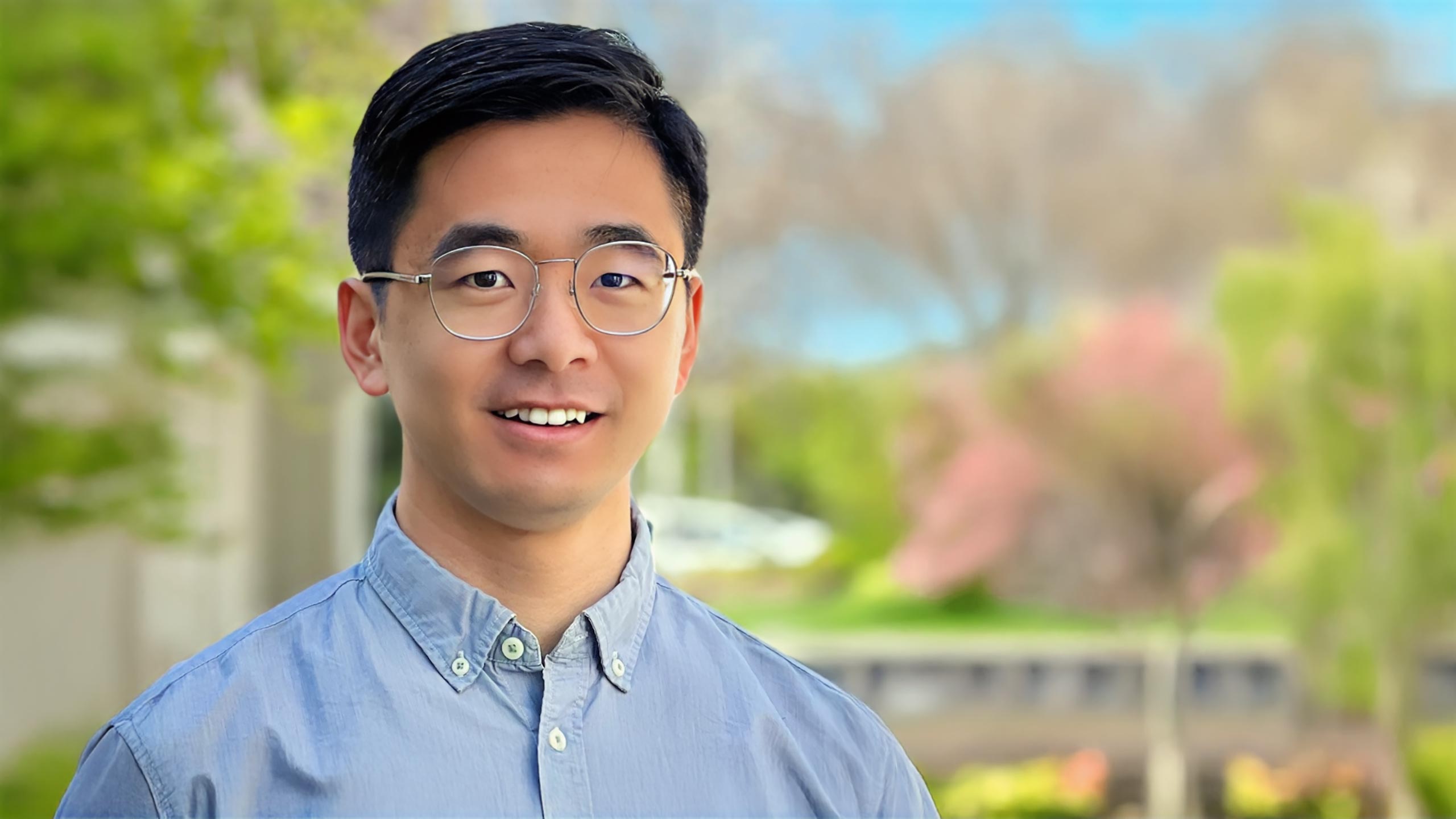 A headshot of Mo Liu standing outside.