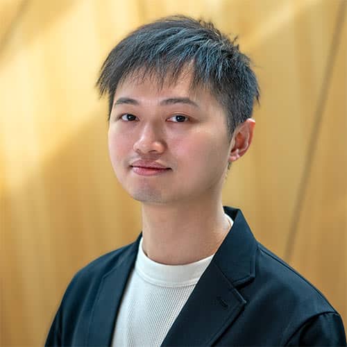 A headshot of student Hou-An Chen standing in front of a light wooden wall.