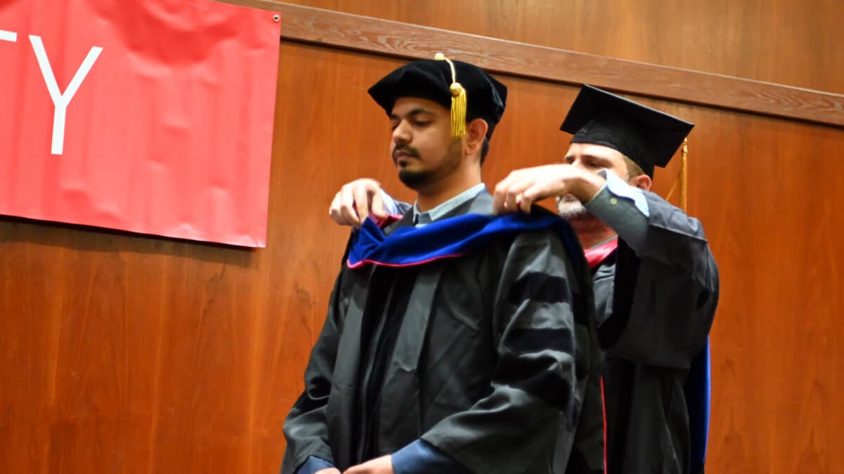 OR Ph.d. student, Soham Mudalgikar, gets hooded by his advisor Andrew Papanicolaou