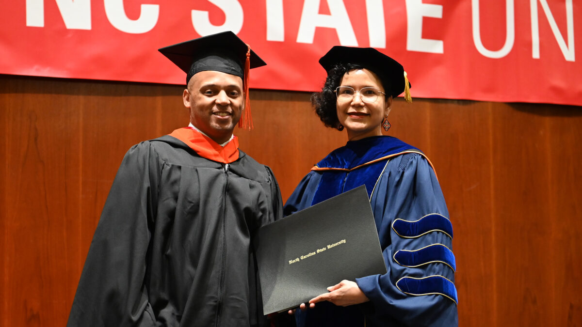 OR MOR student, Andrew Harvey, poses with OR Director, Maria Mayorga, as he receives his degree